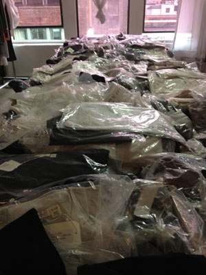 Piles and piles of plastic bagged shirts, sweaters, and tanks stacked inside